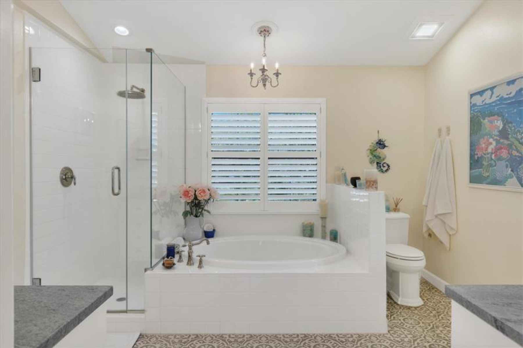 Remodeled owner's bath with frameless glass shower surround and soaking tub