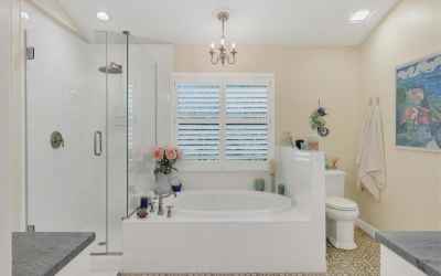 Remodeled owner's bath with frameless glass shower surround and soaking tub