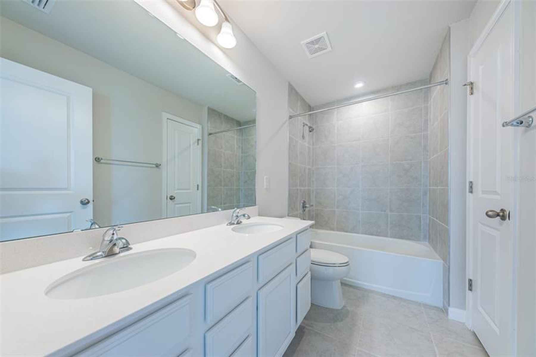 Hall Bath on the 2nd living level has dual sinks, shower/tub and a linen closet