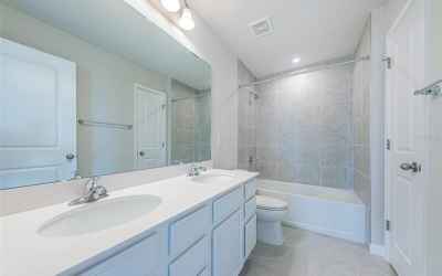 Hall Bath on the 2nd living level has dual sinks, shower/tub and a linen closet